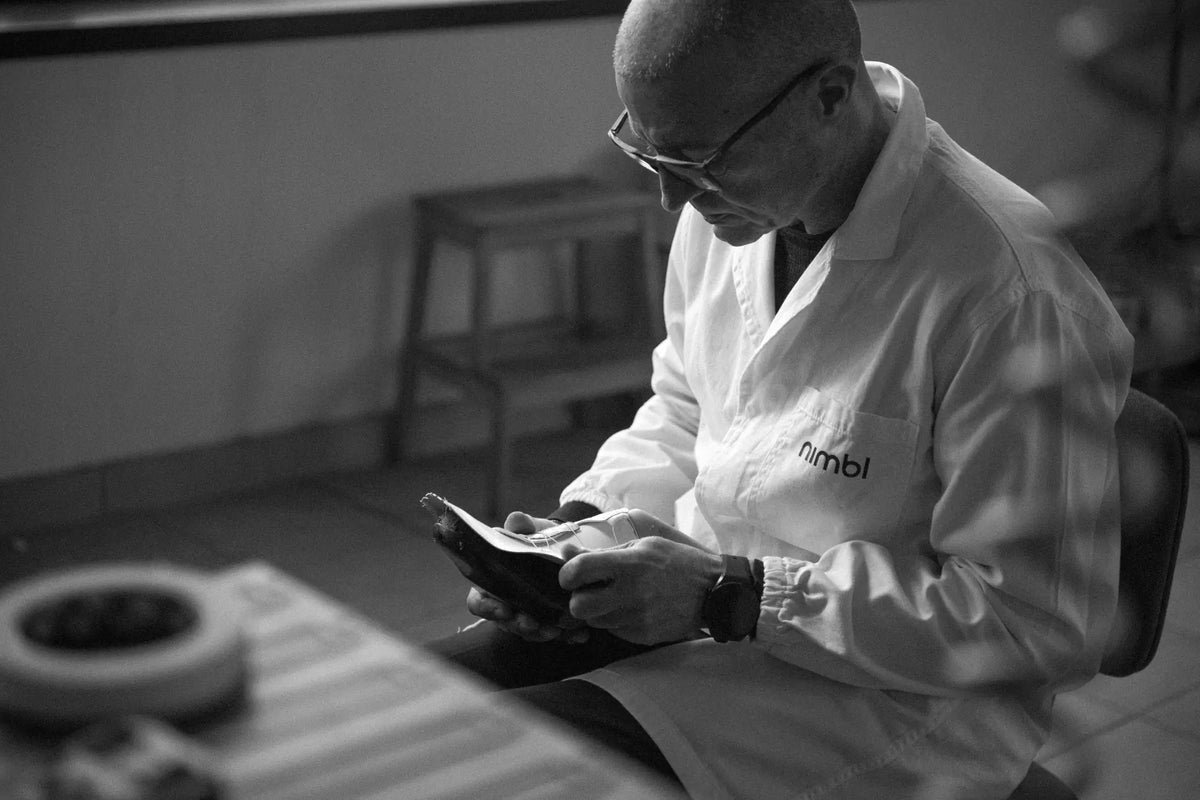Nimbl artisan inspecting a performance cycling shoe in the Italian workshop